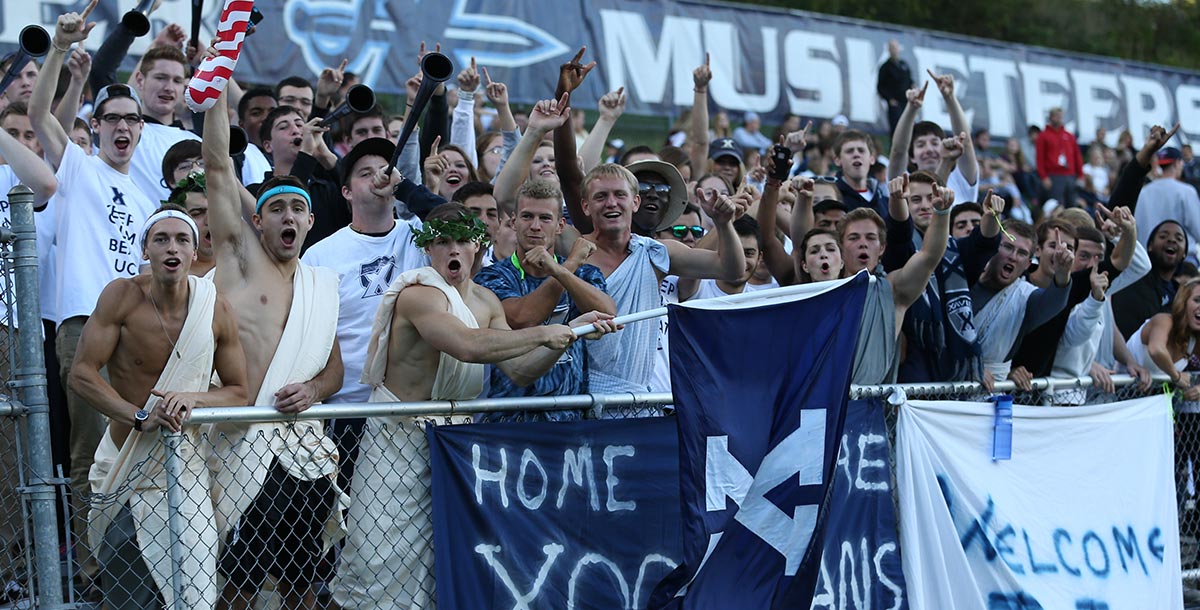 A group of students cheer for Xavier during a soccer game