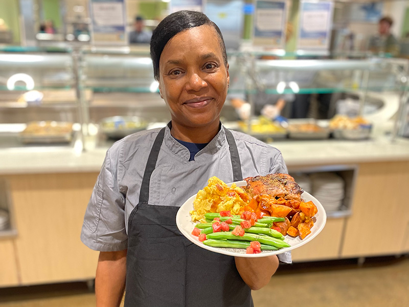Cafeteria staff member holding a plate of food