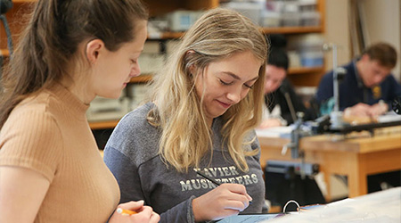 Two Xavier students working together on a project