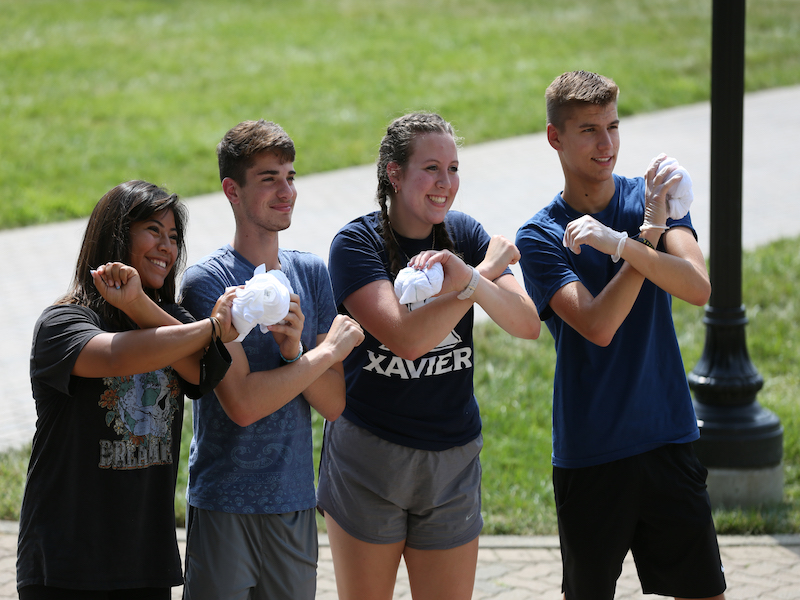 Students making an X with their arms. 