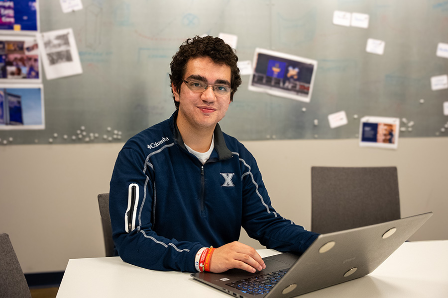 Emmanuel sitting at a desk with a laptop