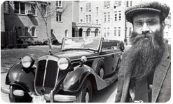 A black and white photo of Dr. Frederick Werner, member of the Xavier Department of Physics, next to a car on campus