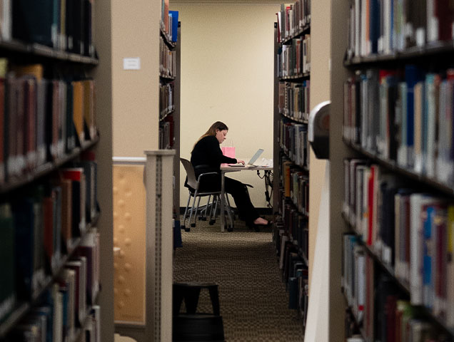 Xavier student at desk studying in library 