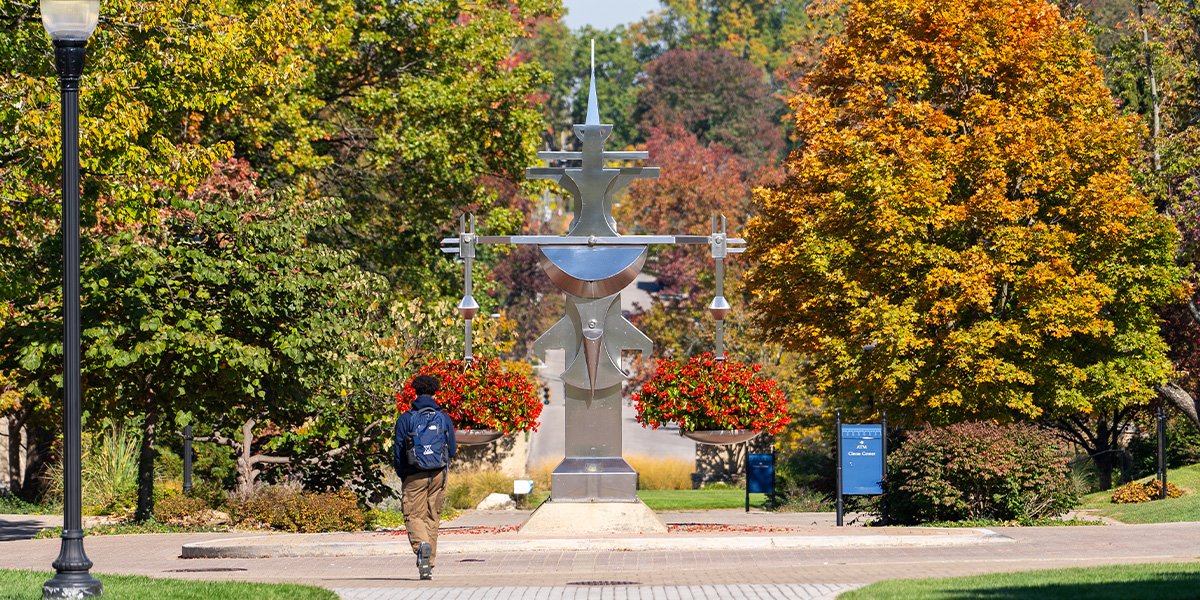 Photo of Campus with student walking by